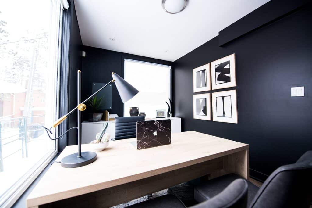 a minimalist office with a black paint and with a large window