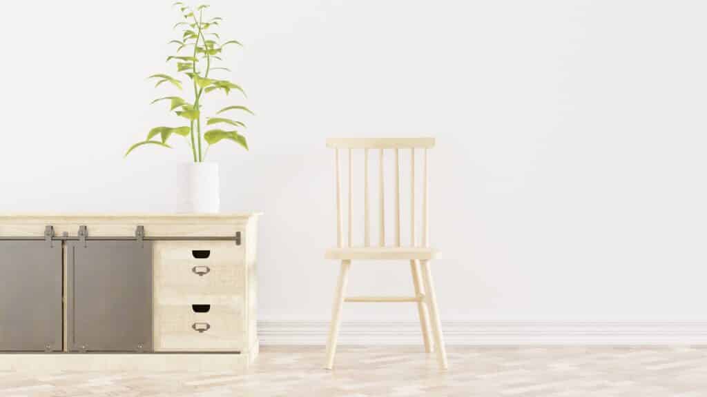 A wooden chair and a side table set against a white wall