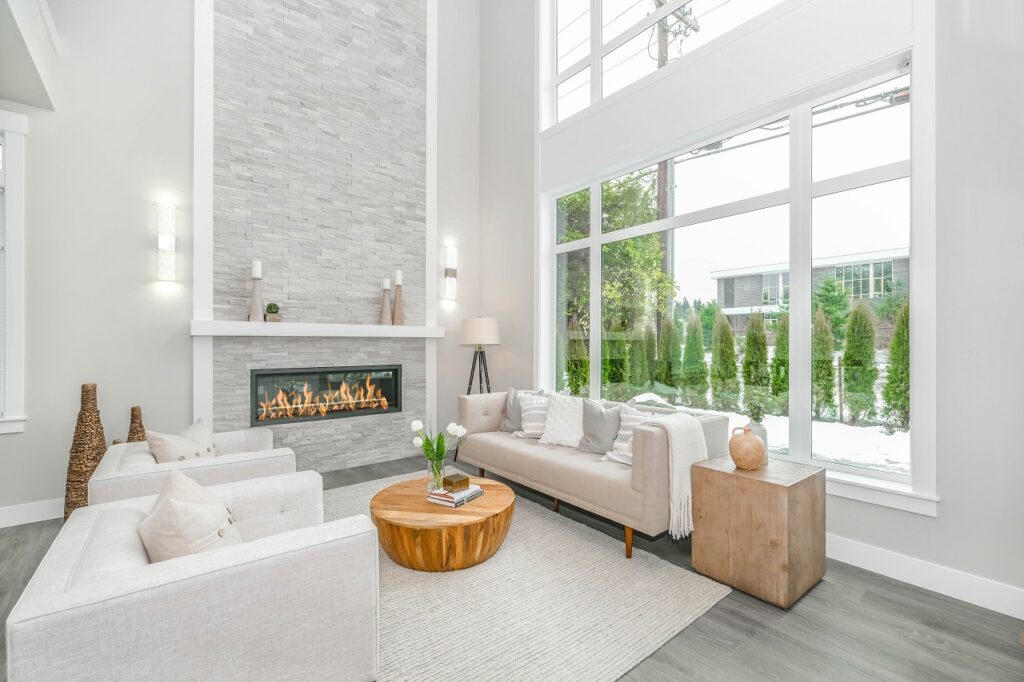 a living room with high ceiling and artificial fireplace