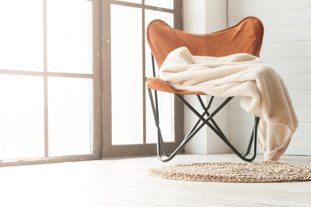 a brown canvas chair with a towel draped over it