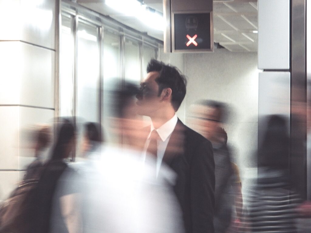 a businessman standing amidst a crowd of rushing people