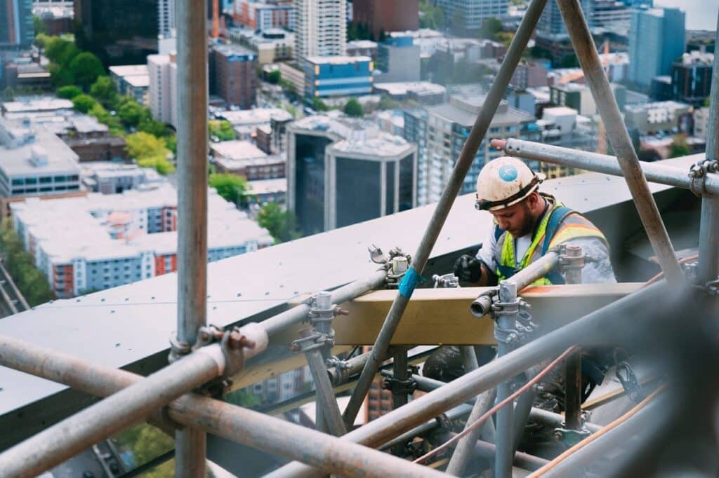a construction worker busy at work while being suspended by a scaffolding