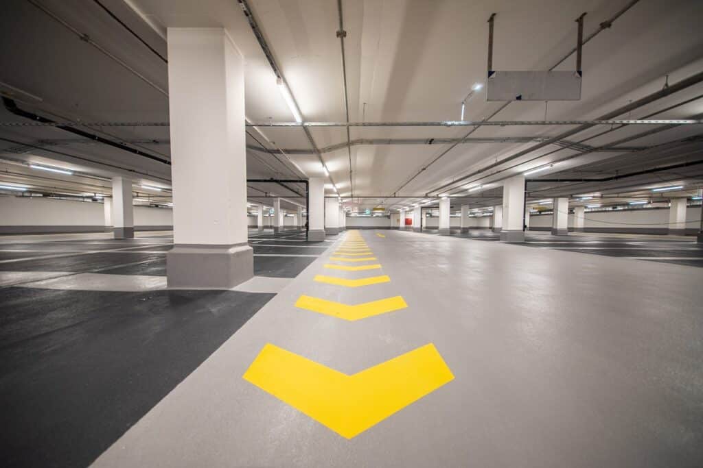 yellow and white arrows painted on a parking lot floor