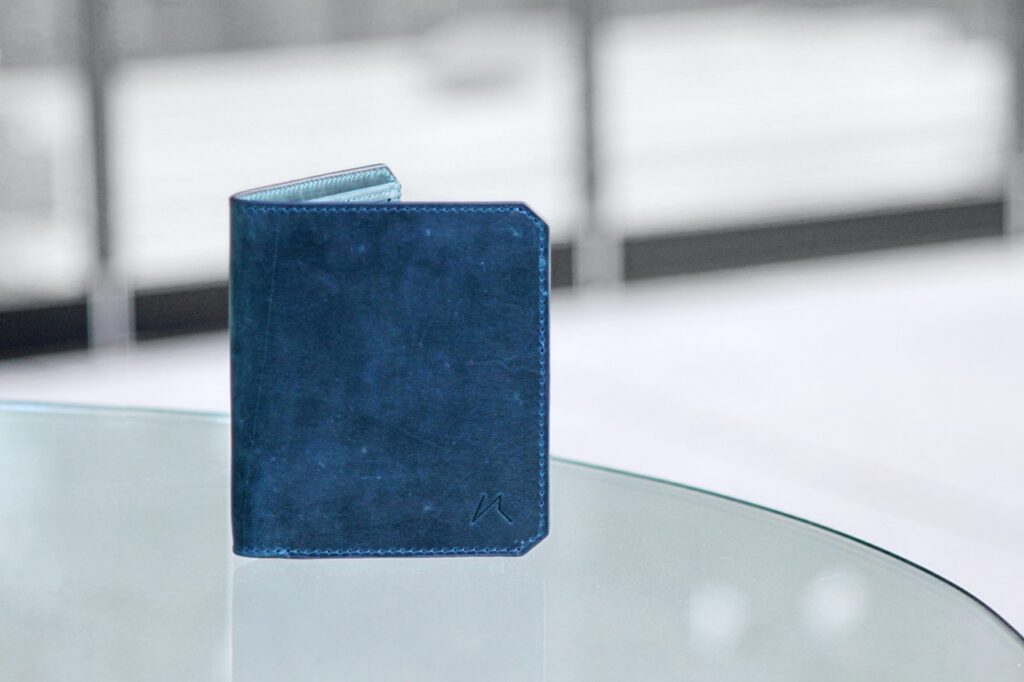 a blue wallet on top of a glass table