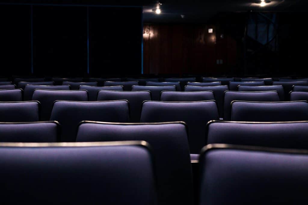 a closeup shot of an empty movie theater's black leather seats