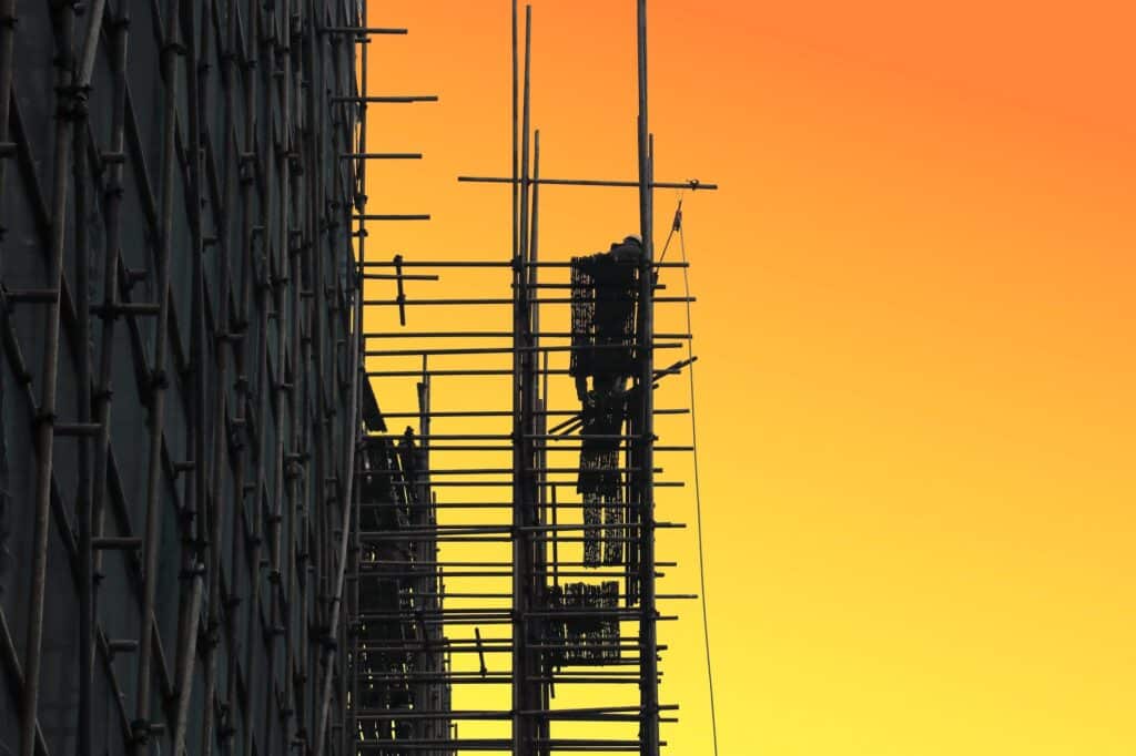 man standing on top of scaffolding on a construction site