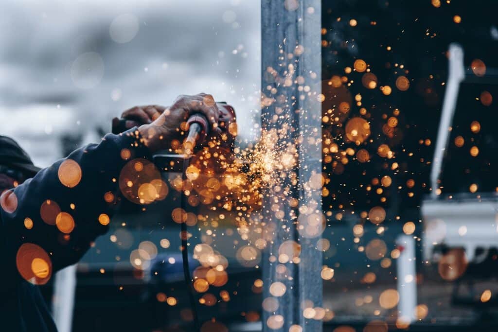 amber reflect on a glass as a welder does welding work on a steel bar