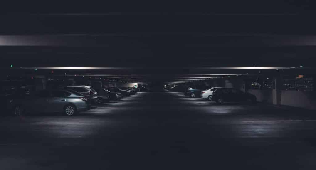 cars lined up in a dark parking building