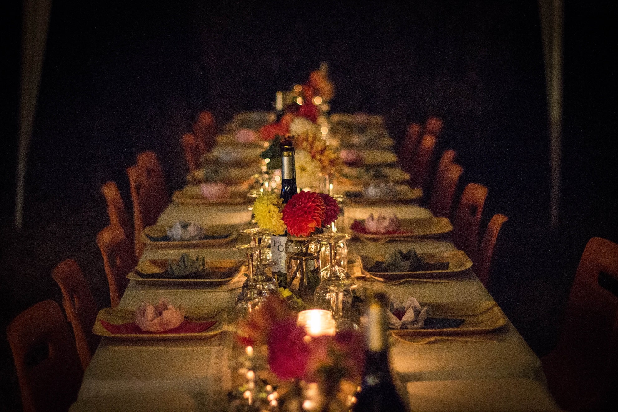 al fresco dinner table with flowers, plates, and silverware