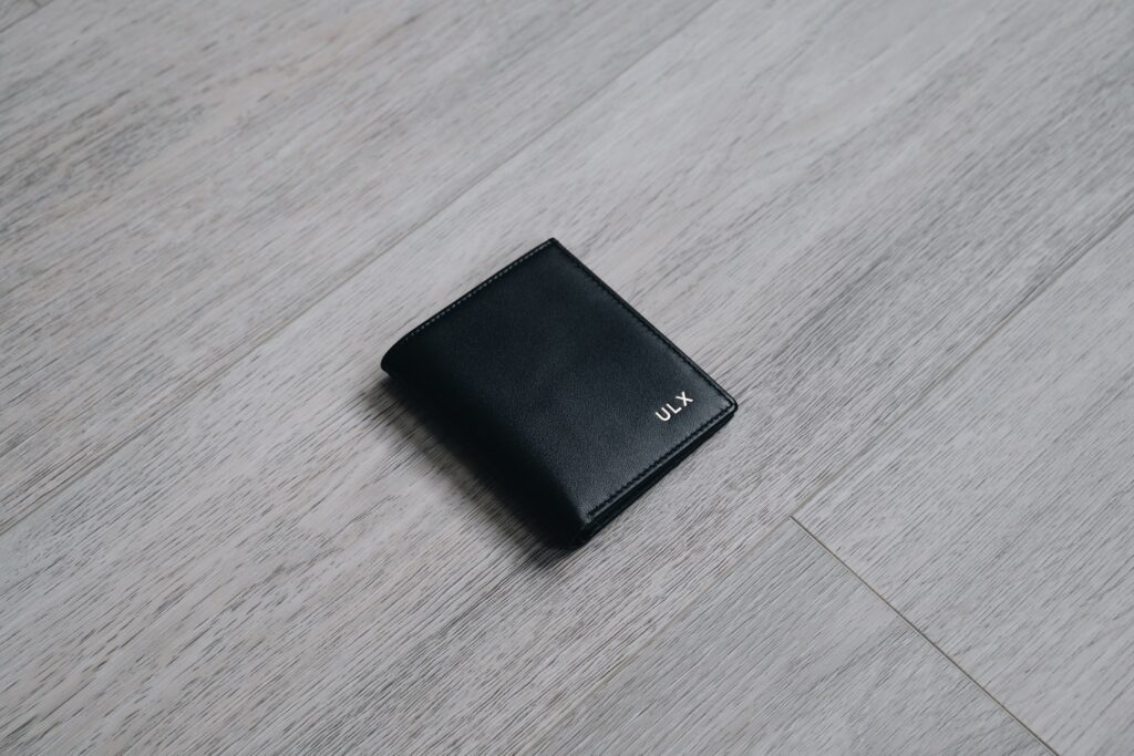 A black ULX wallet placed on a grey counter.