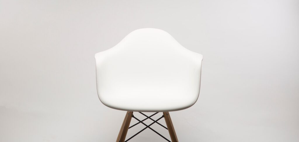 a white minimalistic chair set against a white wall