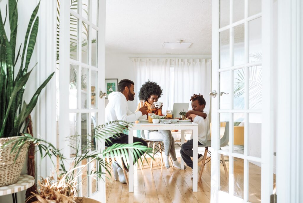 an african-american family enjoying breakfast in their white kitchen-motif at home
