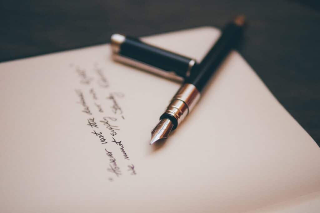 a black and gold fountain pen on top of a paper