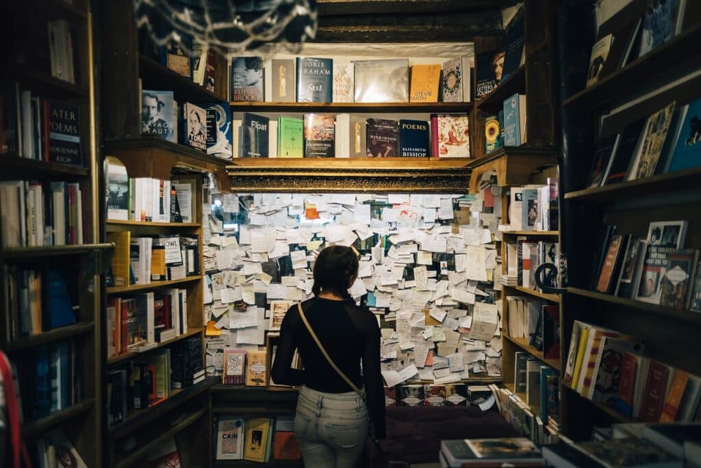 a lady starting at the notes on one wall of a library