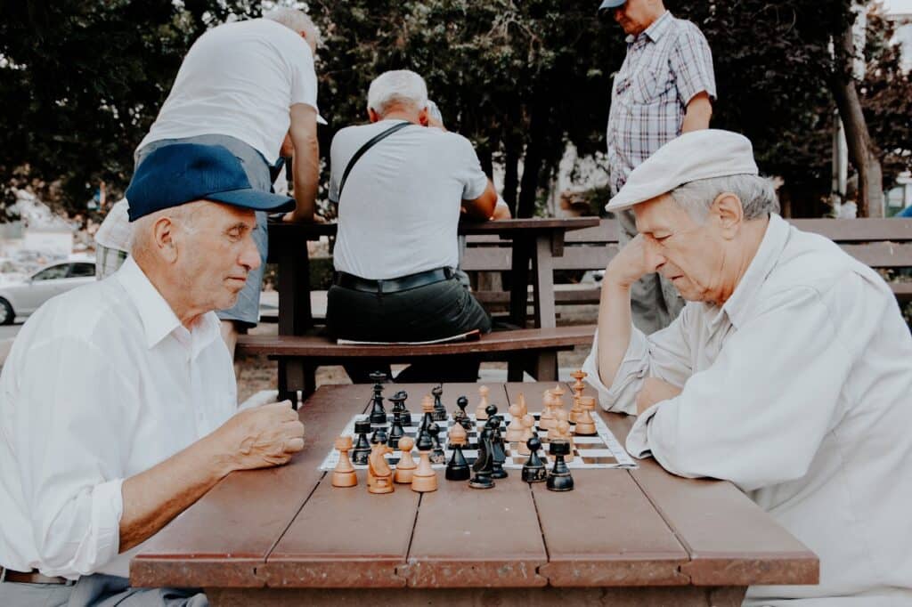 two retired men playing chess in a park