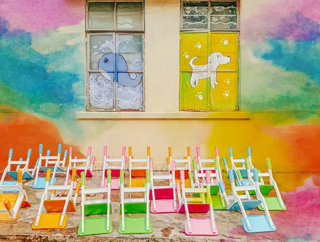 Colourful windows featuring kindergarten artworks, representing the concept of tax deductions for childcare workers.