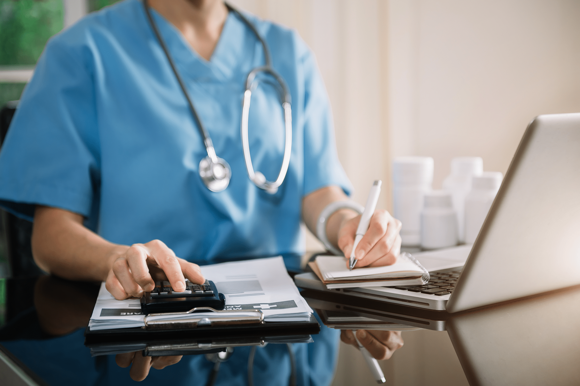 Doctor or accounting department writes a note and uses a calculator to calculate expenses - income.