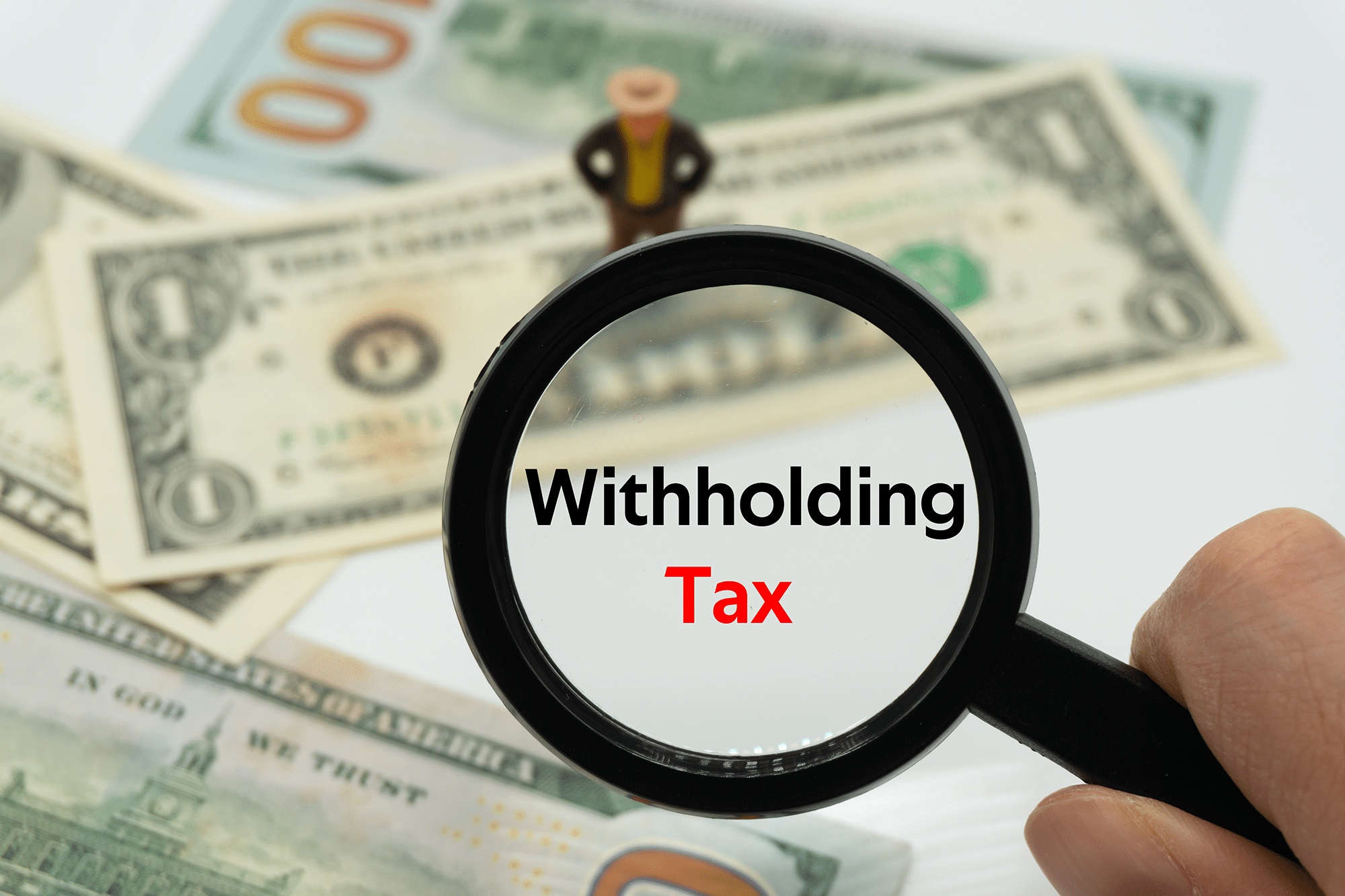 Withholding Tax.Magnifying glass showing the words.