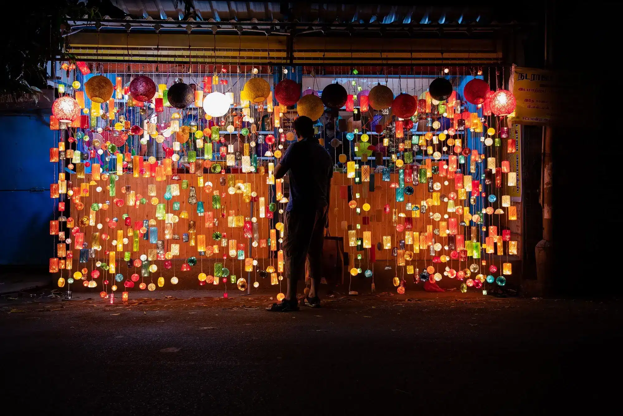 A man looking at a lantern display in a market stall, representing the concept of GST input tax credits.