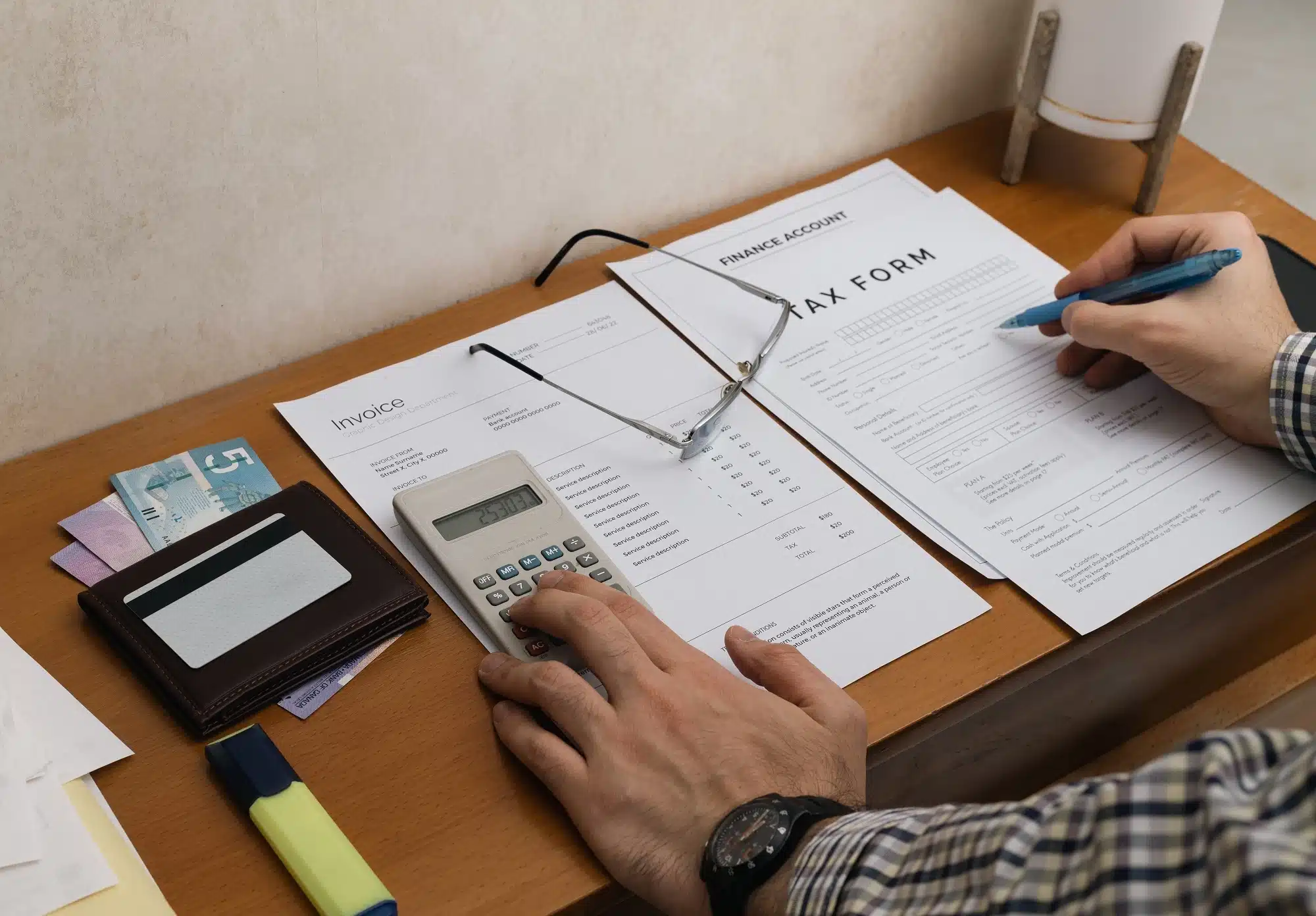 A man using a calculator and filling up a tax form, representing the concept of tax invoice.