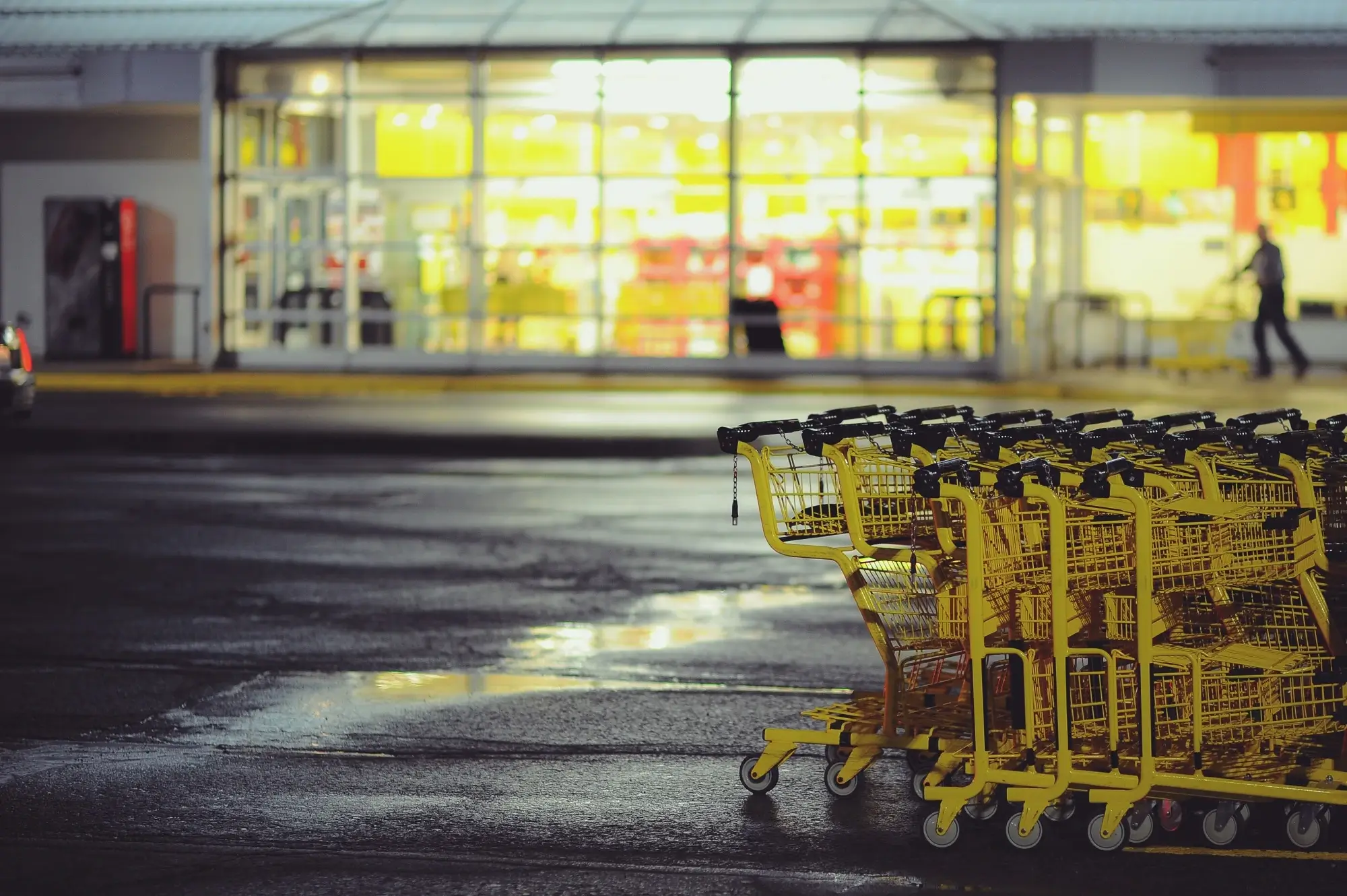 Yellow shopping carts stacked on a parking lot.