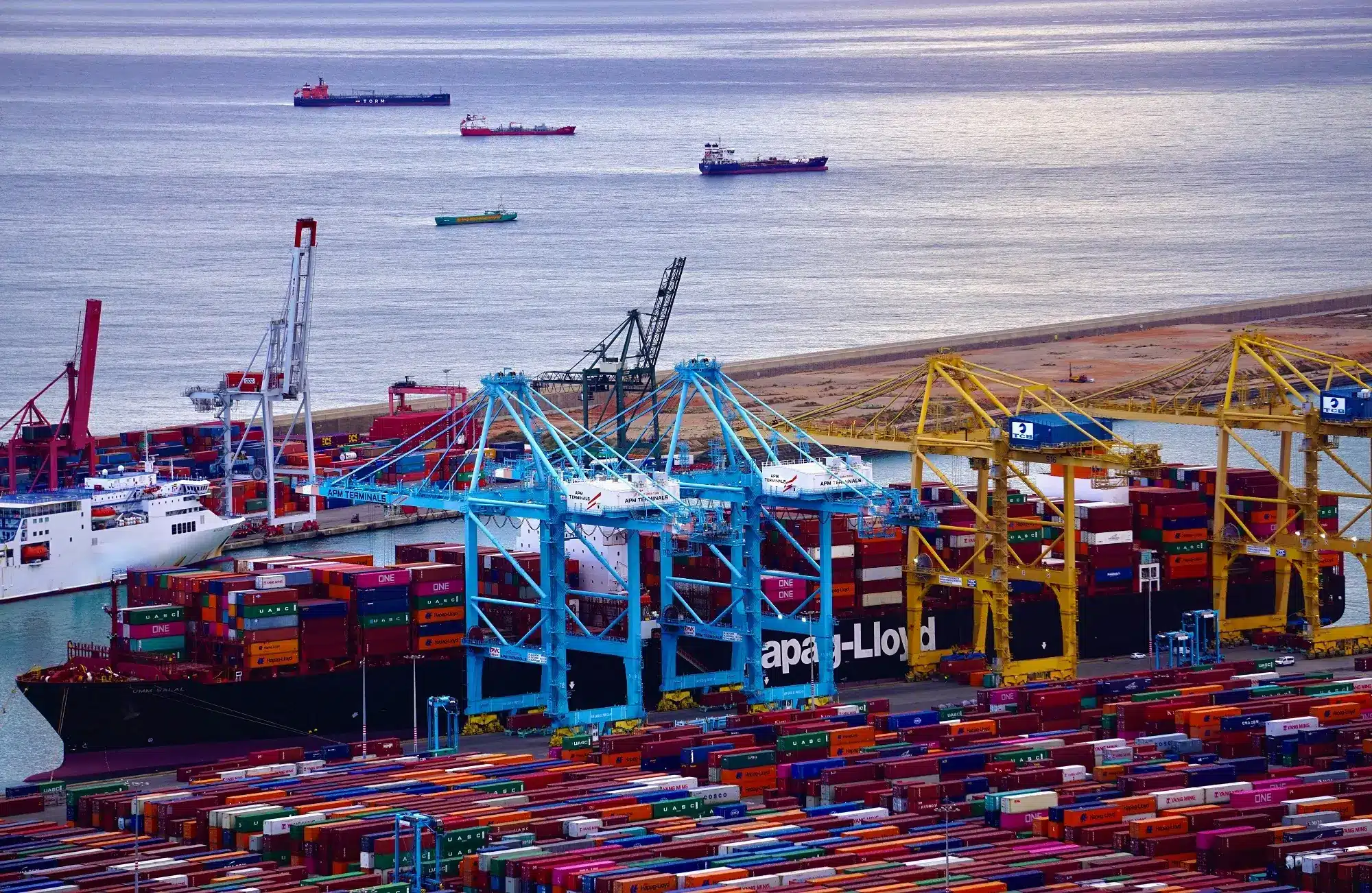 Loading of maritime containers aboard vessels in the seaport of Barcelona, representing the concept of non commercial losses.