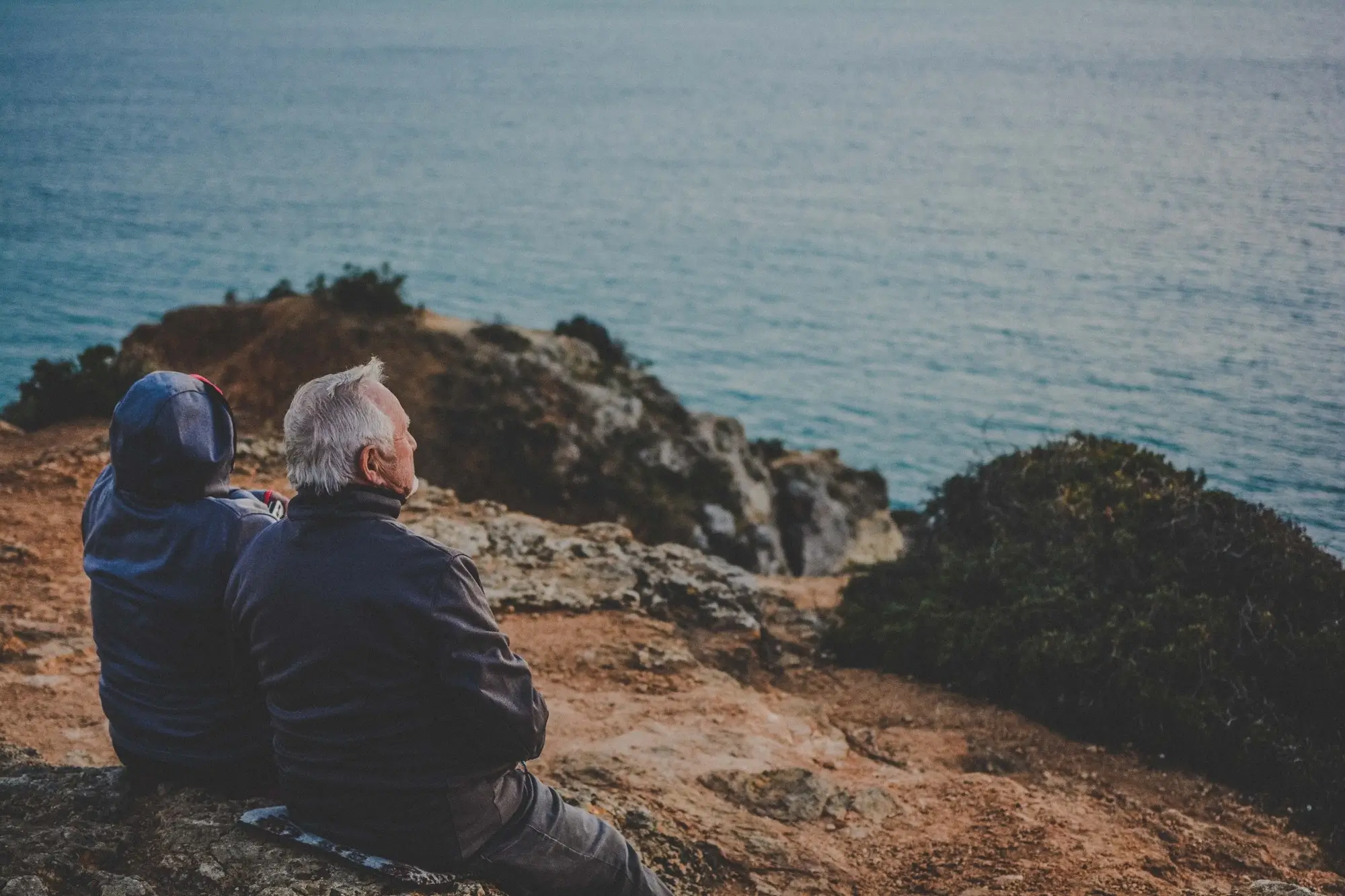 A retired couple watching the ocean.