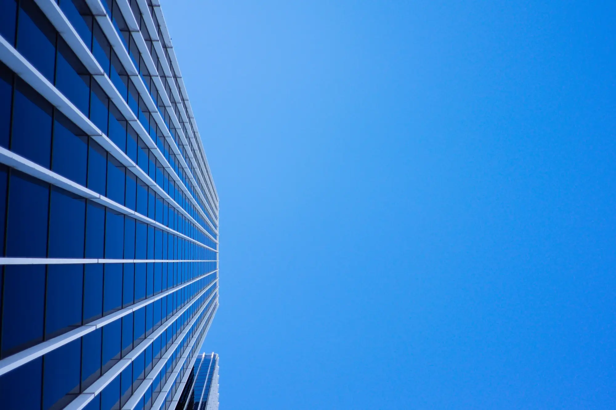A worm's eye view of a skyscraper under the blue sky, representing the concept of controlled foreign company.