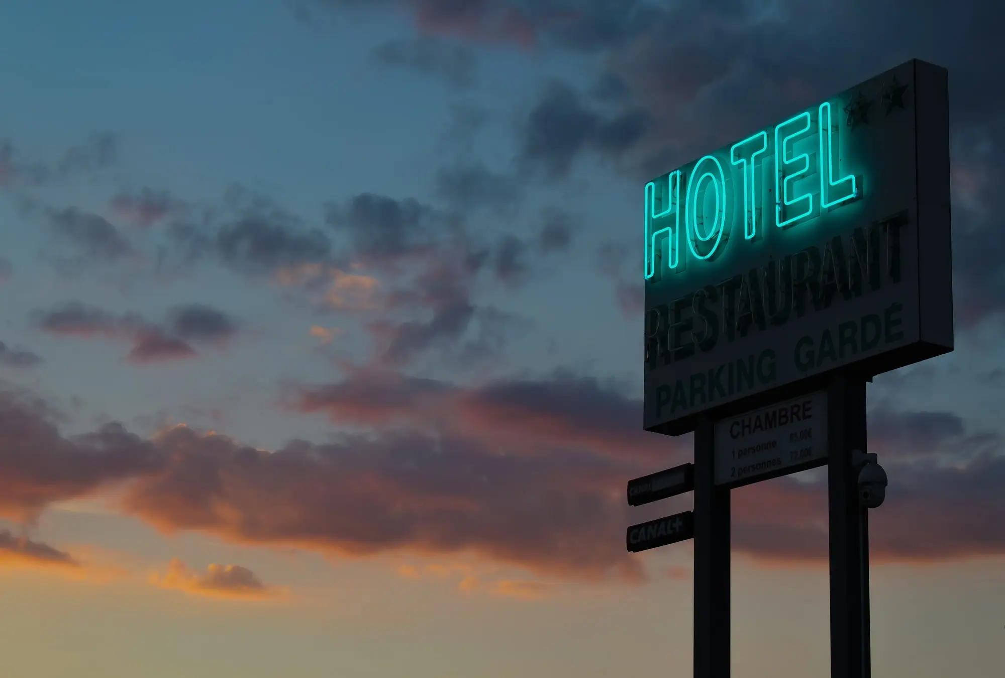 A hotel signage lights in an early evening.