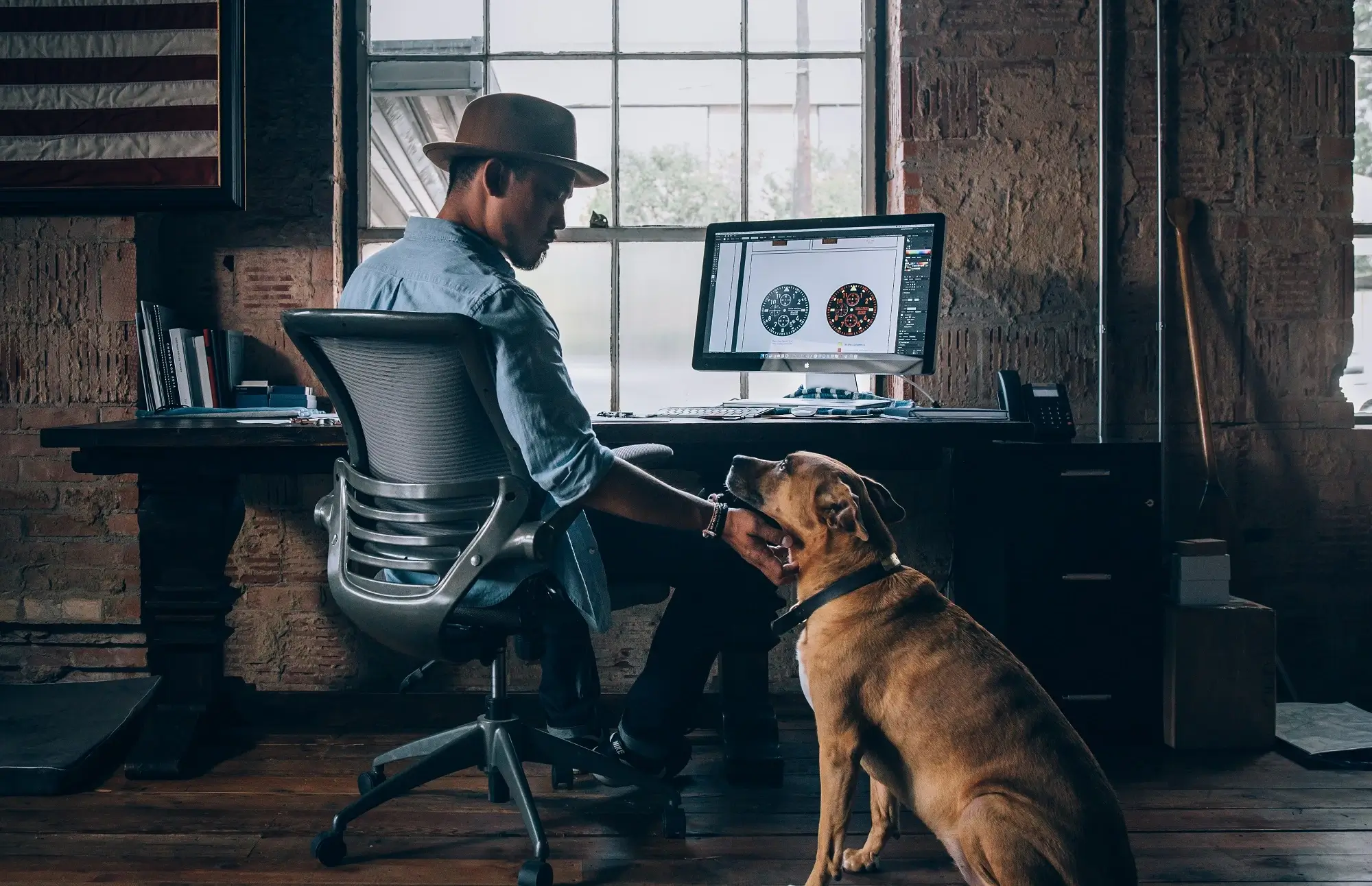 A man petting his dog while working from home.