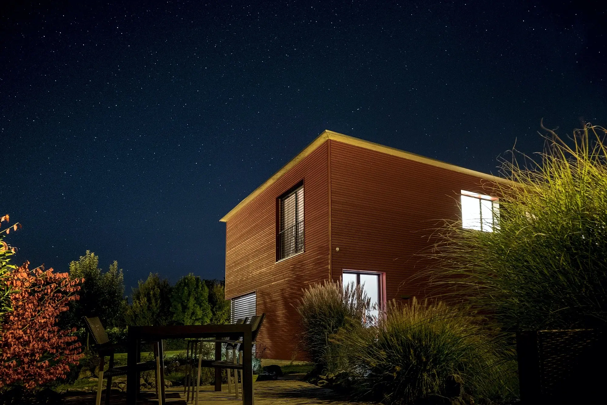 A brown house lit under the night sky, representing the concept of living away from home allowance.