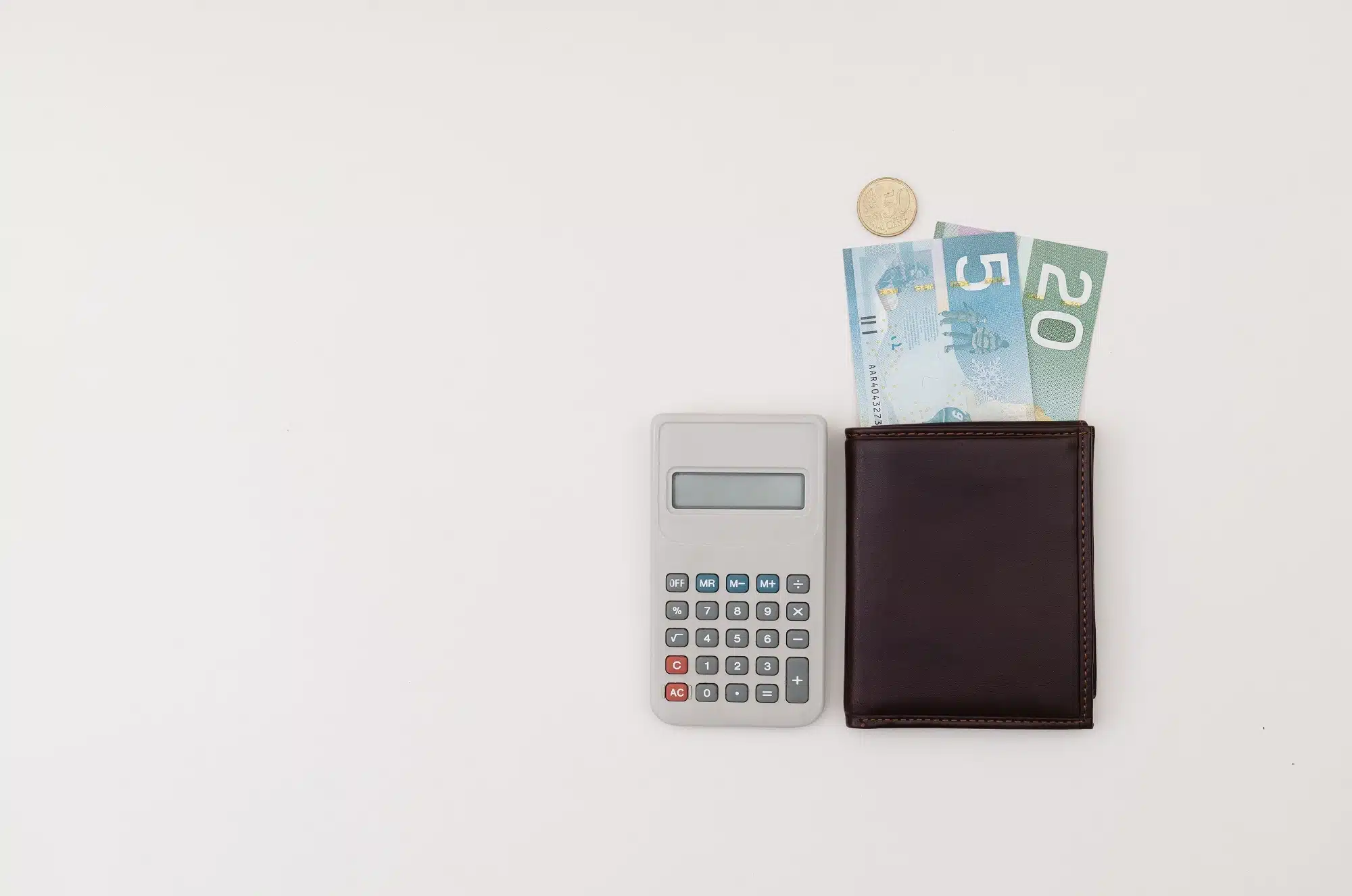 A black wallet with a couple of bills sticking out and a calculator.