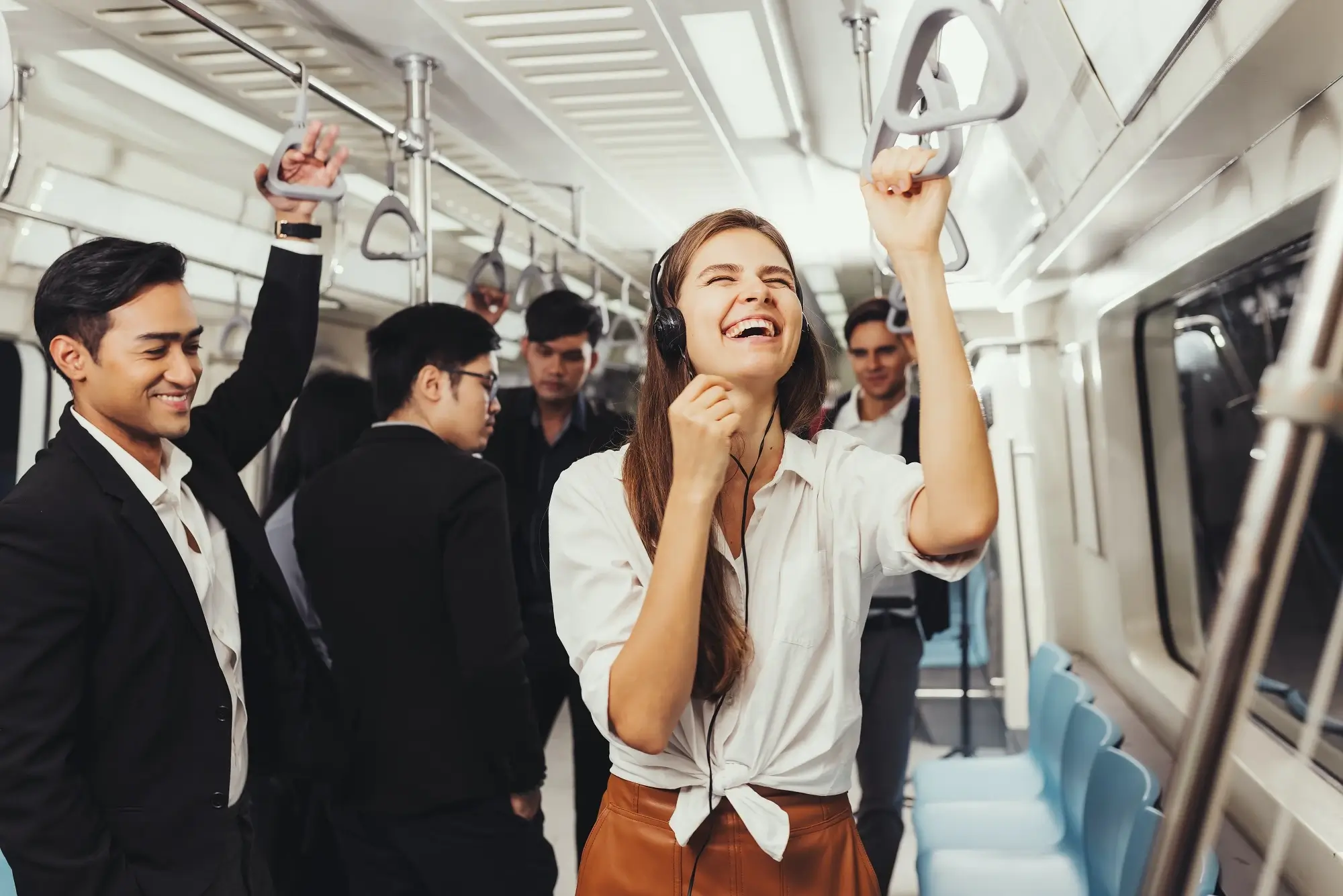 A man and a woman sharing a laugh inside a train.
