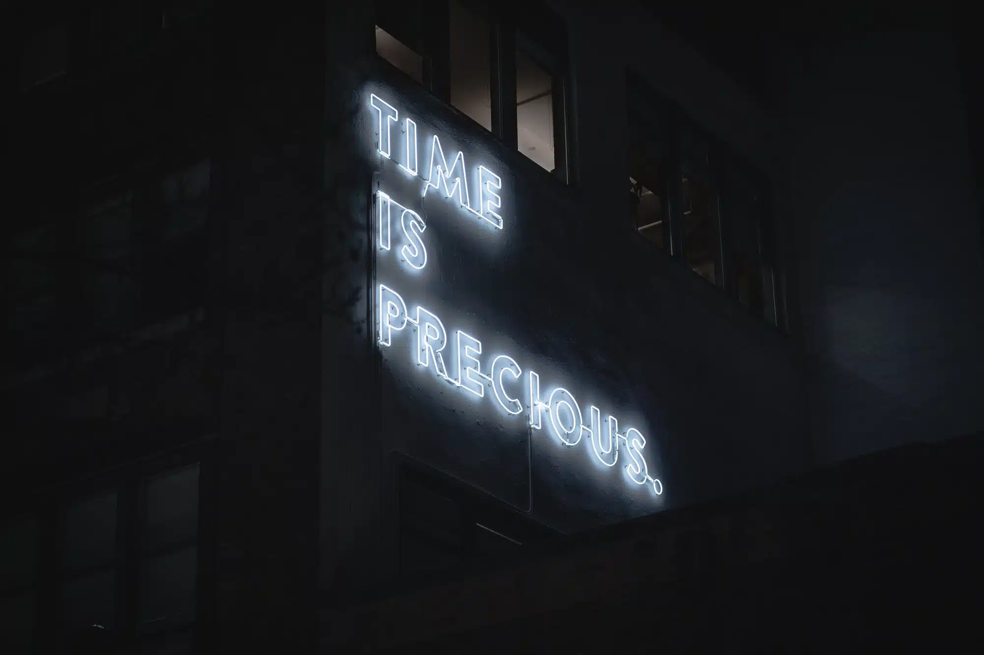 A neon sign that says, 'Time is precious, representing the concept of ordinary time earnings.