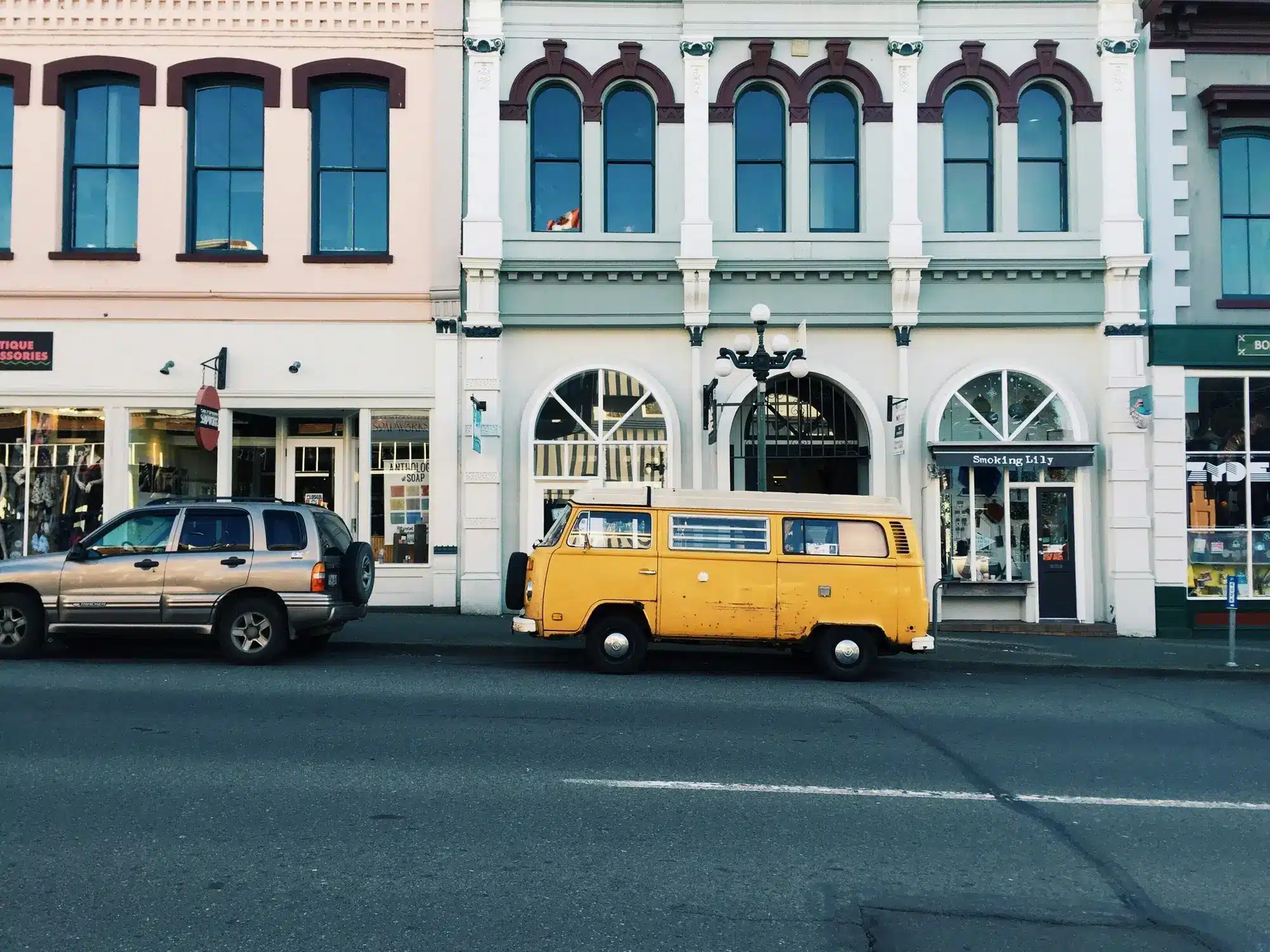 A yellow vintage van parked in front of a building, representing the concept of temporary residents.